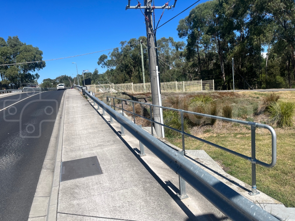 Galvanised key clamp guardrail installed above a culvert wing wall, protecting members of the public from the large drop